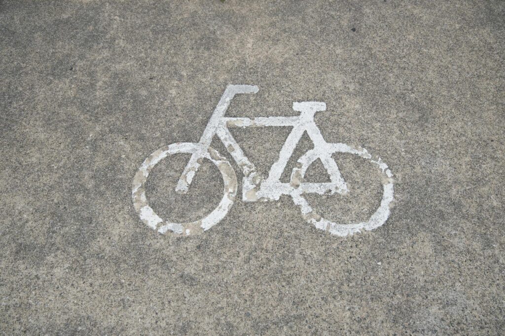 Close-up of a faded bicycle symbol painted on urban pavement surface.
