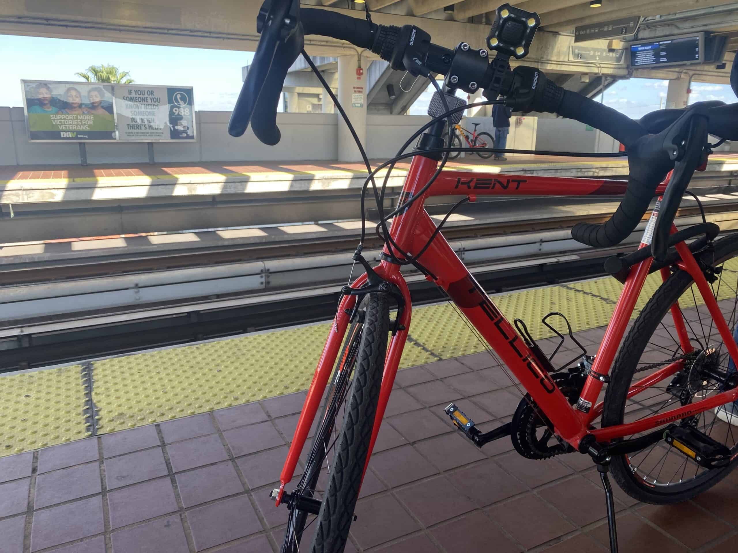Red Kent hybrid bike at the bus station for travel and commuting in urban environments.