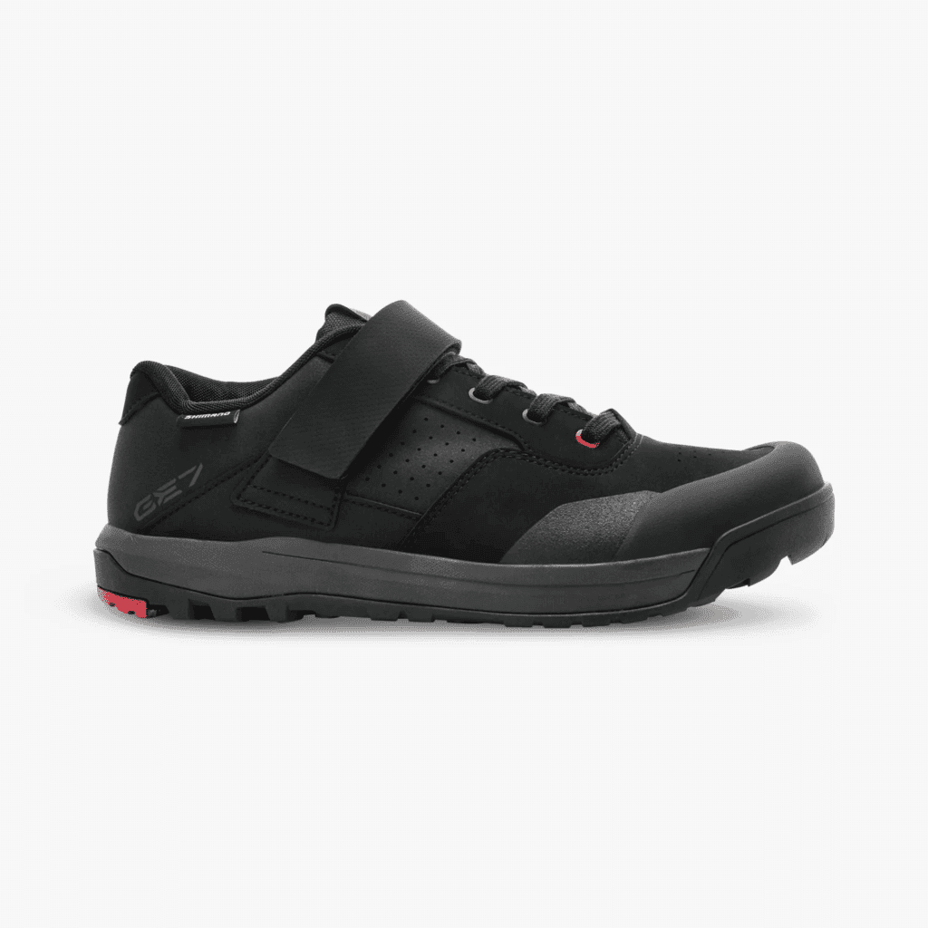 Versatile black mountain biking shoe with secure strap and durable sole for trail riding.
